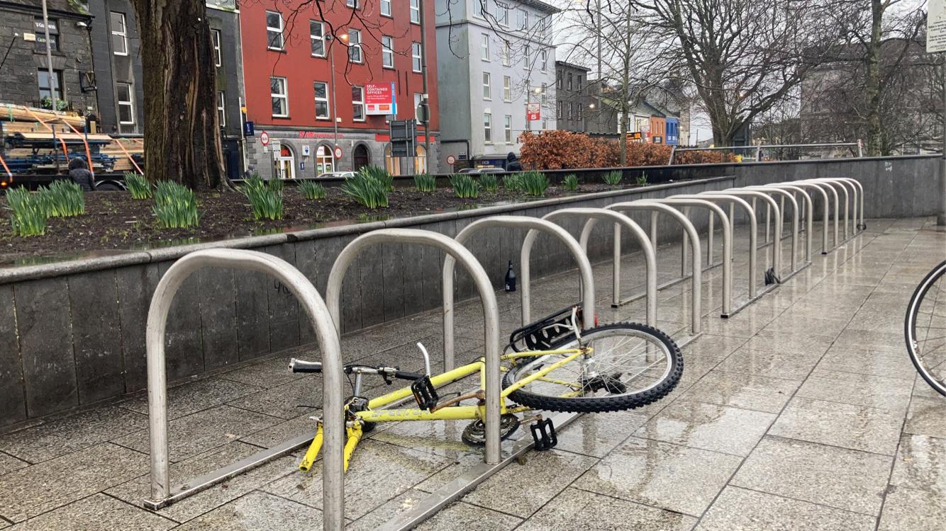 Photo of an abandoned bike attached to a bike rack