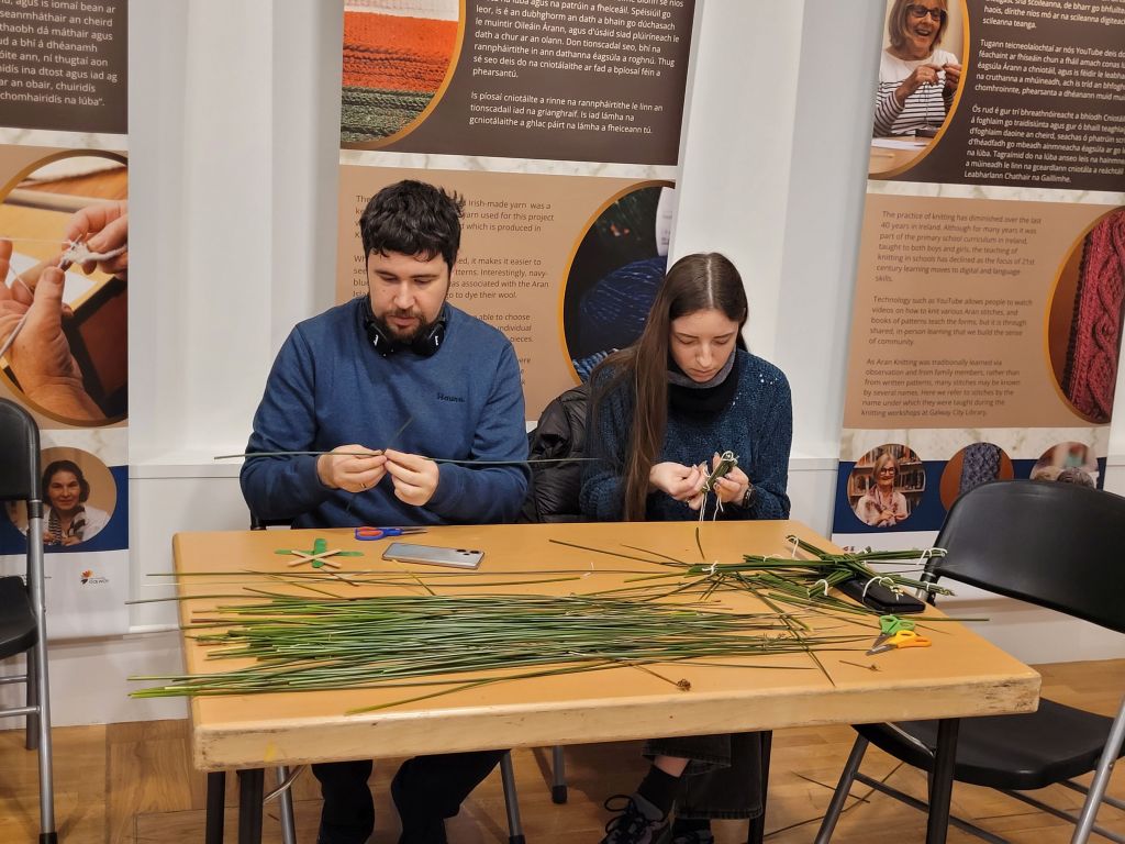 Photo of a man and a woman making St Brigids Crosses