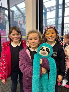 Smiling children holding a toy monkey