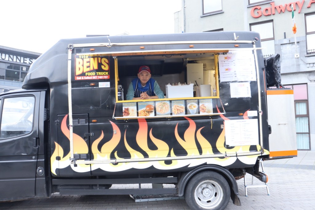 Mr Ben Bertulfo standing inside his food truck, Tito Ben's Food Truck.