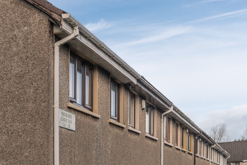 A row of terraced houses. They're brown and we can just see the upstairs windows