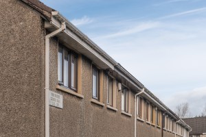 A row of terraced houses. They're brown and we can just see the upstairs windows