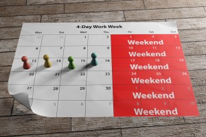 A paper calendar on a desk showing a weekend marked in red over three days - Friday, Saturday and Sunday
