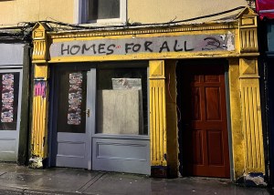 "Homes for all" spray painted on a house wall in Galway City.