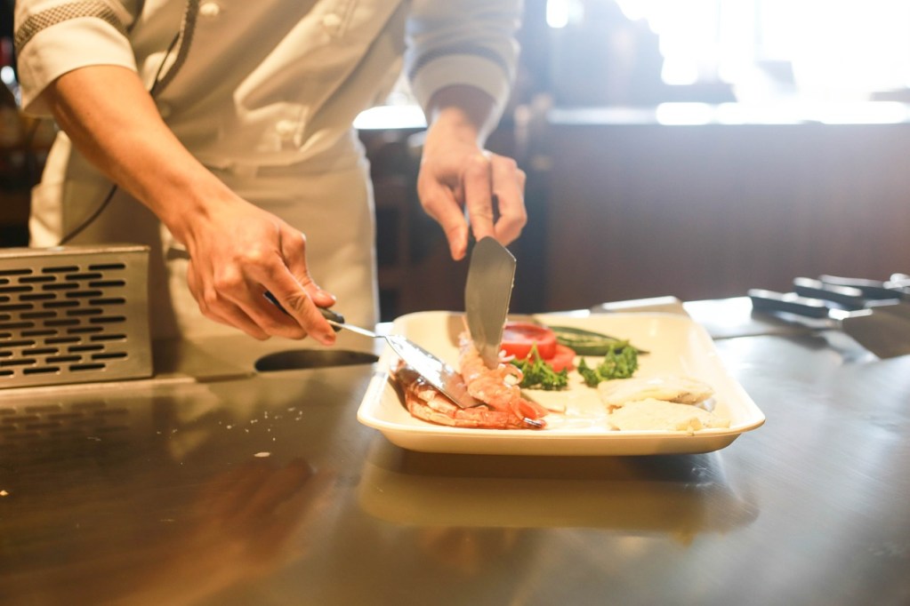 A chef serving food in a restaurant.