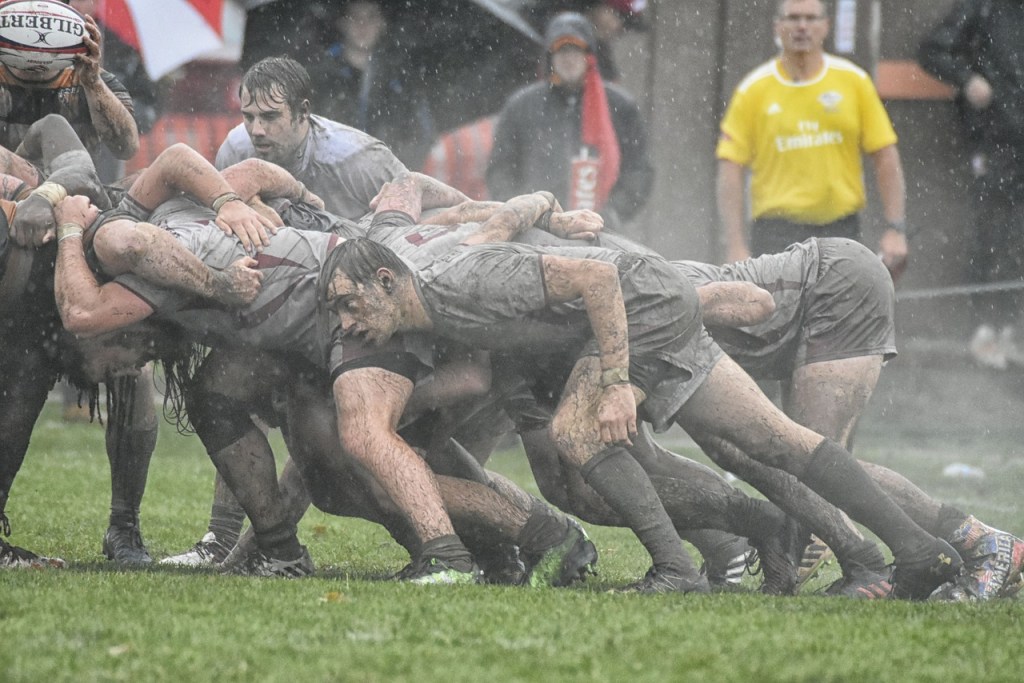 Rugby players take part in a scrum during a game.