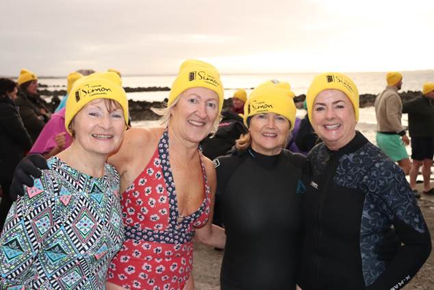 Four women on beach after Dip at Dawn swim
